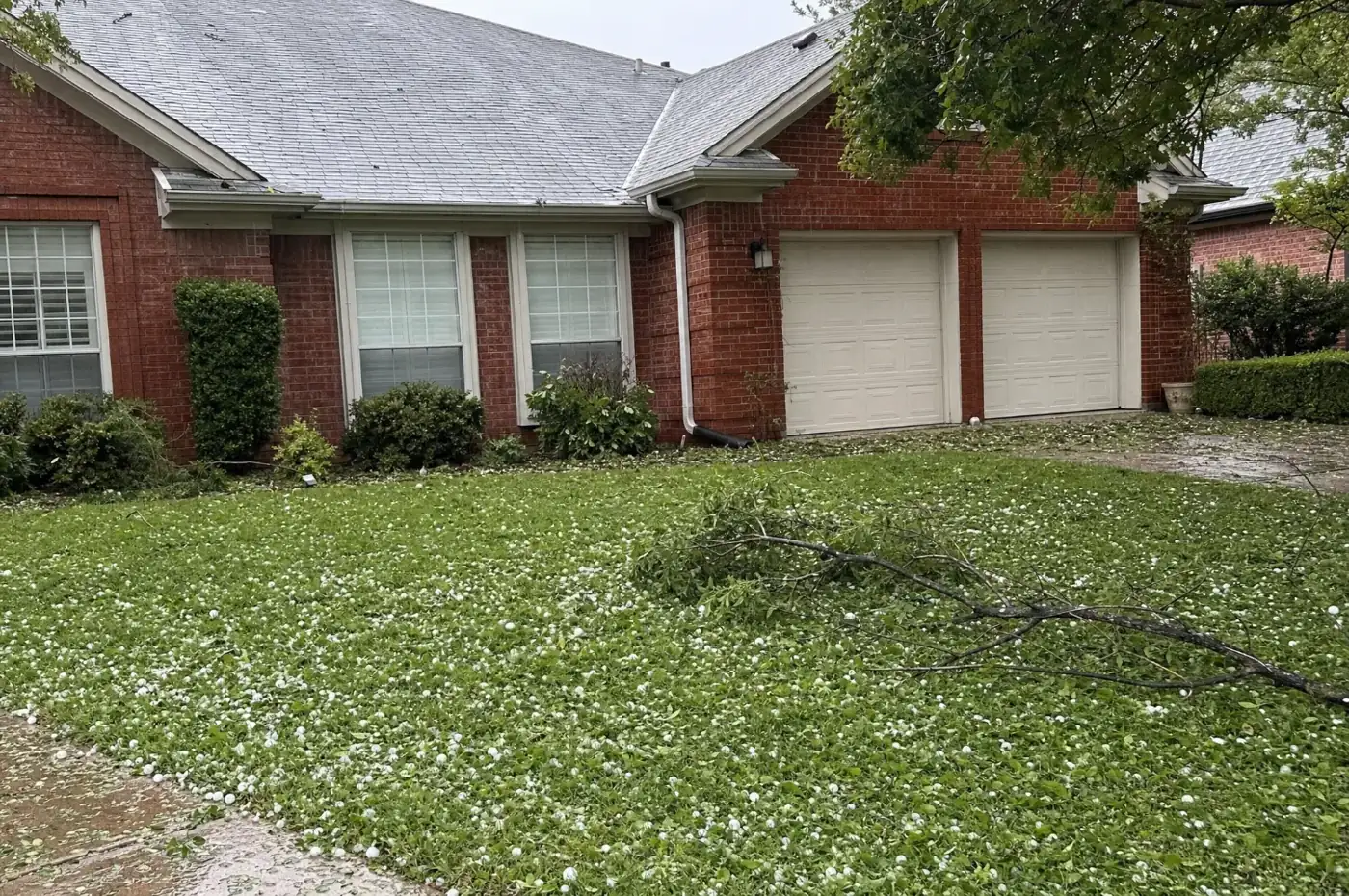 Hail and storm debris on the lawn of a North Texas brick home