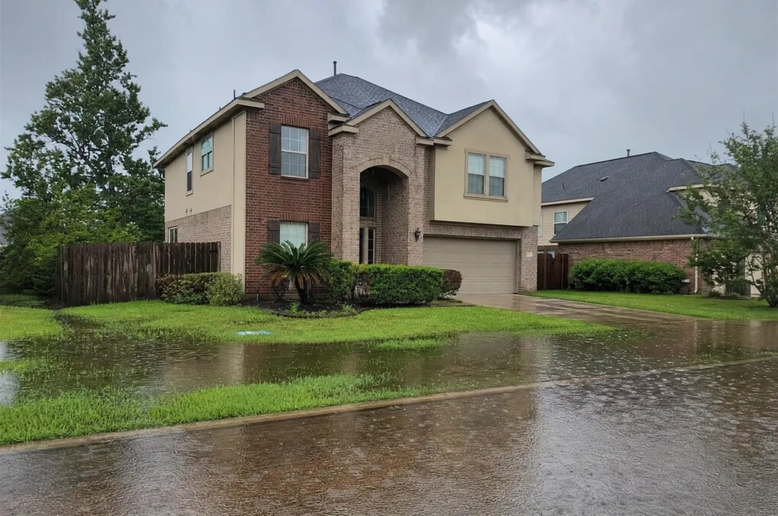 Flooded yard and street in front of a Houston-area home